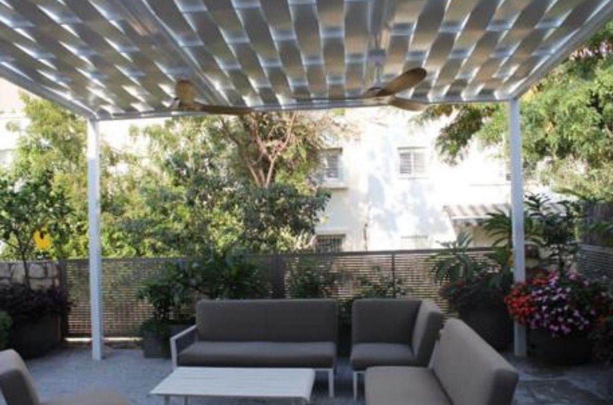 Aluminum pergola over an outdoor lounge with ceiling fans